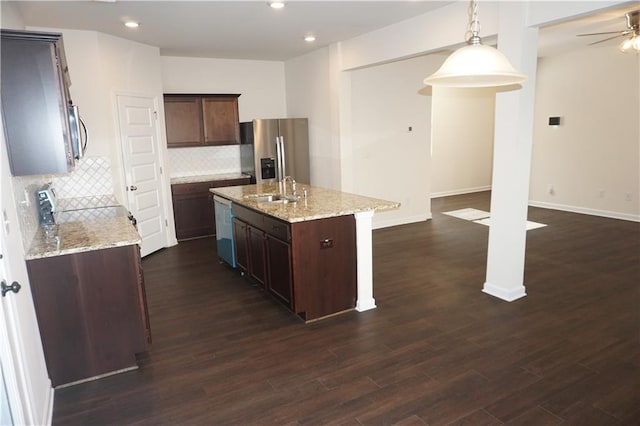 kitchen featuring a sink, appliances with stainless steel finishes, an island with sink, and dark wood finished floors