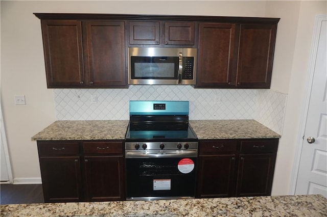 kitchen featuring tasteful backsplash, dark brown cabinets, appliances with stainless steel finishes, and light stone countertops