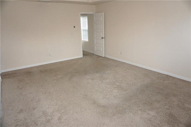 carpeted spare room featuring baseboards