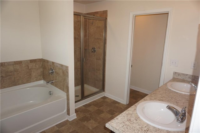 full bathroom featuring a bath, a stall shower, double vanity, and a sink