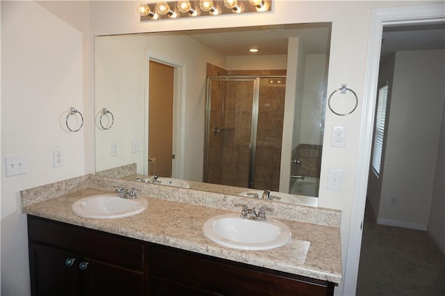 full bath with double vanity, a stall shower, and a sink