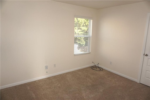 unfurnished room featuring light carpet and baseboards