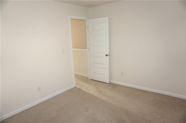 empty room featuring carpet floors and baseboards