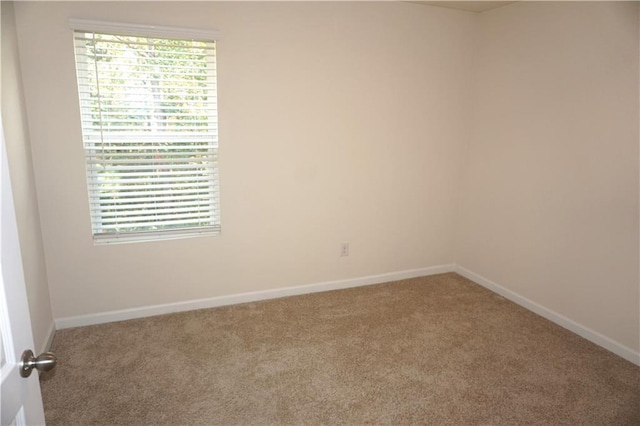 carpeted spare room featuring baseboards