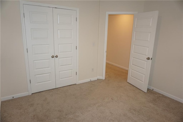 unfurnished bedroom with carpet floors, baseboards, and a closet