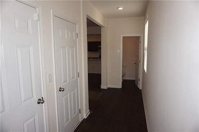 hallway with baseboards and dark wood finished floors