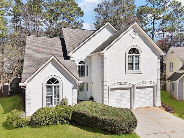 view of front of property with a garage, concrete driveway, roof with shingles, stucco siding, and a front yard