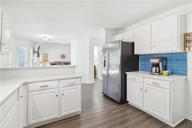 kitchen with dark wood finished floors, tasteful backsplash, white cabinetry, a peninsula, and stainless steel fridge with ice dispenser