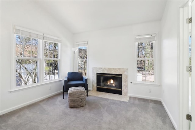 living area featuring lofted ceiling, baseboards, a fireplace, and carpet