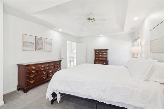 bedroom featuring ceiling fan, recessed lighting, light carpet, visible vents, and a tray ceiling