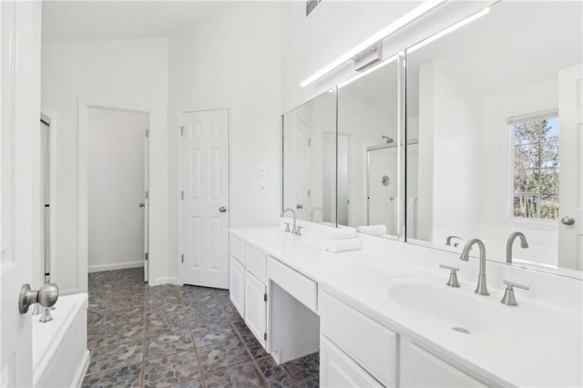 full bath with double vanity, a sink, a bath, and a shower stall