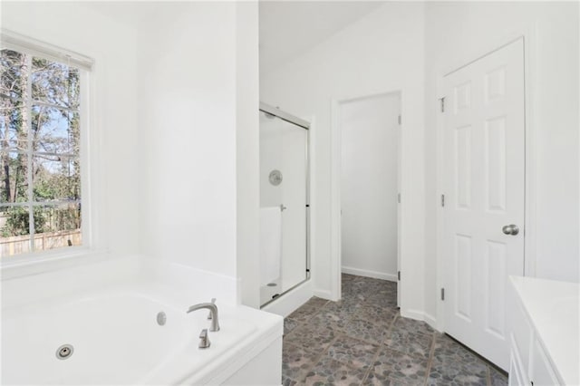 full bathroom featuring a whirlpool tub and a shower stall