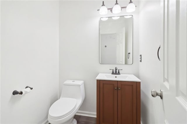 bathroom featuring vanity, toilet, and baseboards