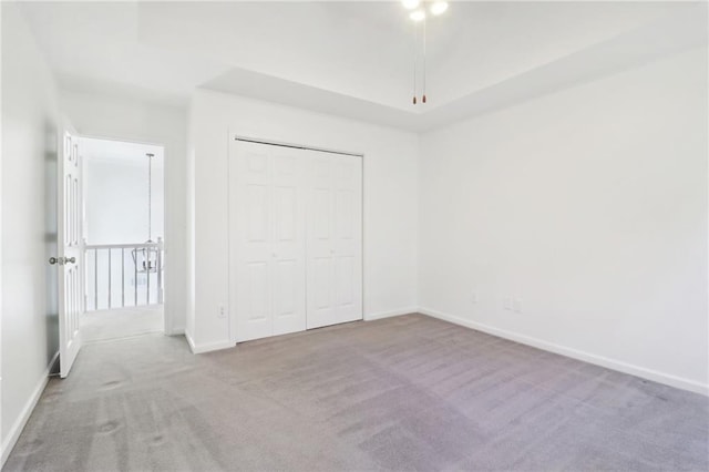 unfurnished bedroom featuring carpet floors, a closet, and baseboards