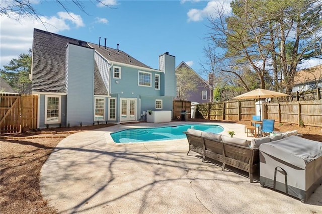 view of pool featuring a patio, a fenced backyard, an outdoor hangout area, french doors, and a fenced in pool