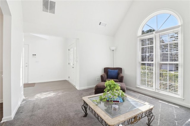 sitting room featuring high vaulted ceiling, baseboards, visible vents, and carpet