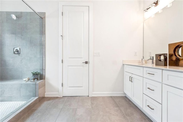 bathroom with tiled shower, vanity, and tile patterned floors