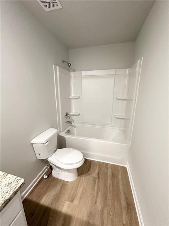 bathroom with vanity, wood finished floors, visible vents, tub / shower combination, and toilet