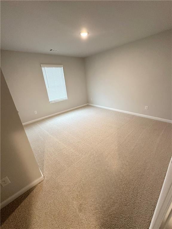 unfurnished room with baseboards and light carpet