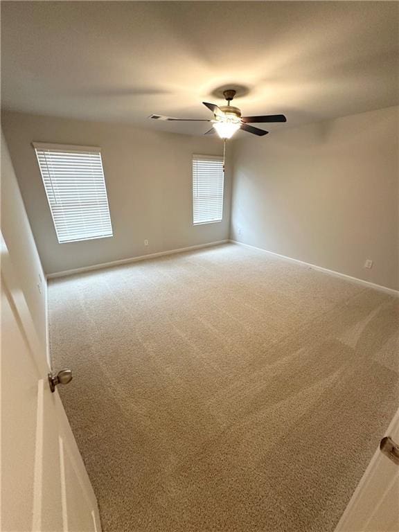 empty room featuring a ceiling fan, baseboards, and carpet floors