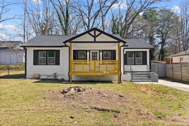 bungalow-style house featuring crawl space, roof with shingles, a front yard, and fence