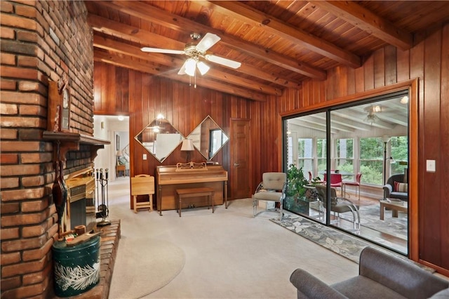 living area featuring ceiling fan, beamed ceiling, and carpet floors