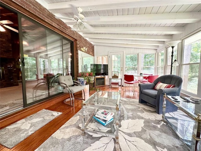 sunroom with a wealth of natural light, lofted ceiling with beams, and ceiling fan