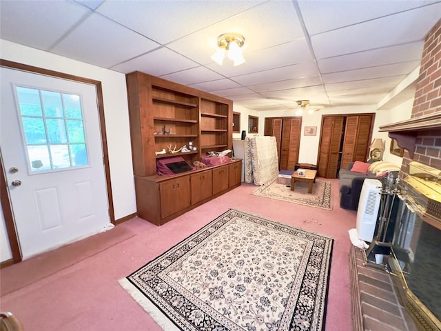 living room with a paneled ceiling, light carpet, and ceiling fan