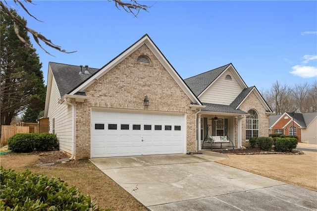 traditional-style house with brick siding, roof with shingles, concrete driveway, an attached garage, and fence