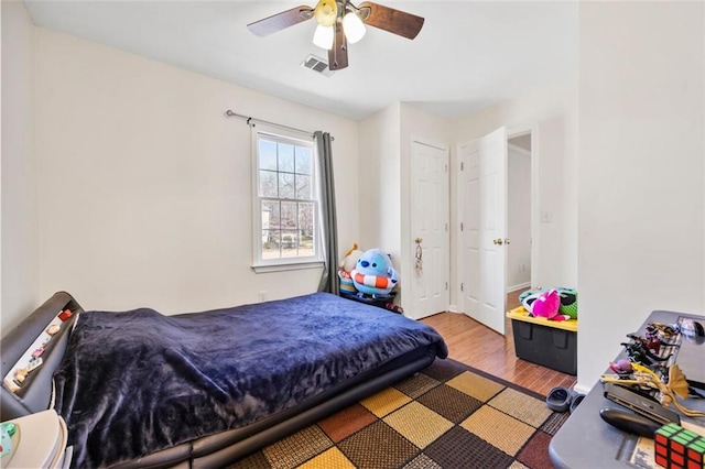 bedroom featuring visible vents, wood finished floors, and a ceiling fan