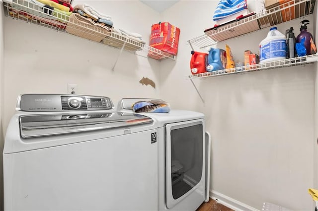 clothes washing area featuring washer and dryer, laundry area, and baseboards