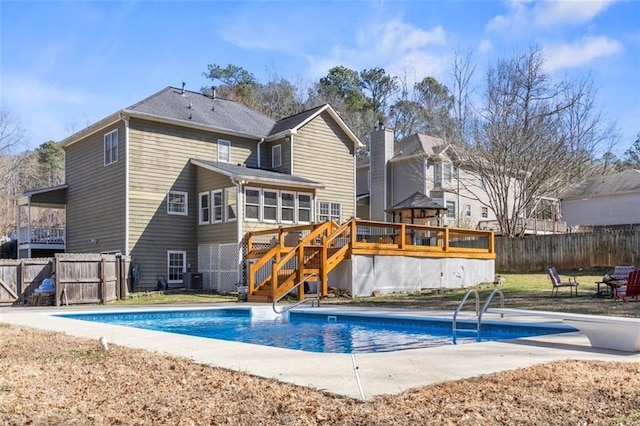 rear view of property featuring stairway, fence, a fenced in pool, central AC, and a deck