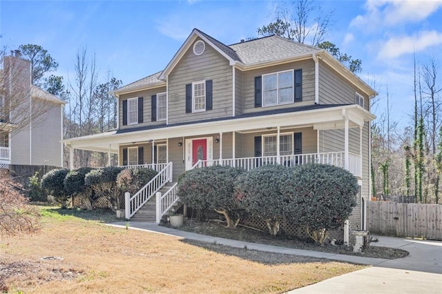 view of front facade with a porch, concrete driveway, and fence