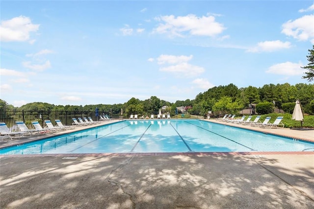 community pool with a patio and fence