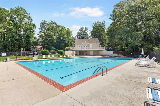 pool with a patio area and fence