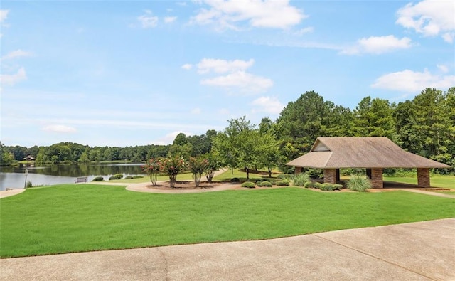 surrounding community featuring a water view and a lawn