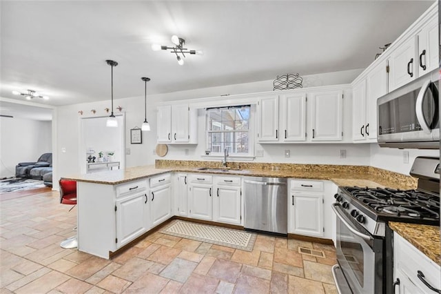 kitchen featuring visible vents, a peninsula, a sink, stainless steel appliances, and open floor plan