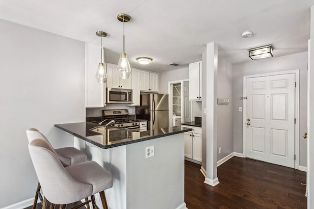 244 13th St NE Unit 302, Atlanta, GA 30309 - kitchen featuring stainless steel appliances, a peninsula, white cabinetry, and a breakfast bar area