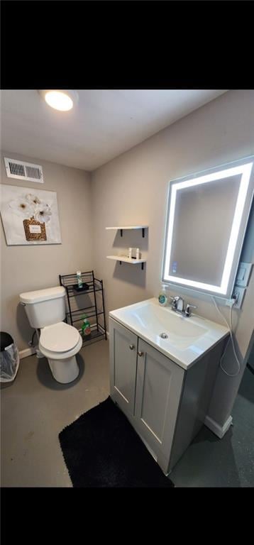 bathroom featuring concrete flooring, vanity, and toilet