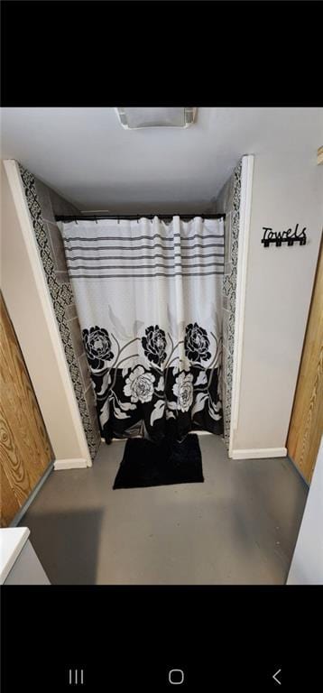 bathroom with vanity, a shower with curtain, and concrete flooring