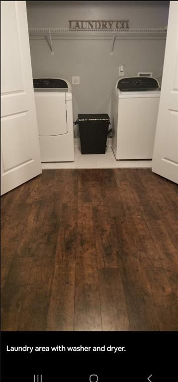 laundry area with separate washer and dryer and hardwood / wood-style flooring