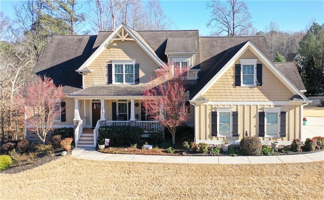 craftsman house with a porch, board and batten siding, and a front yard