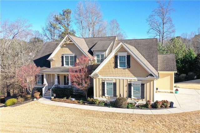 craftsman-style house featuring a front lawn, a porch, board and batten siding, and concrete driveway