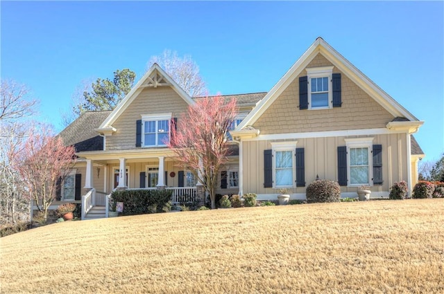 craftsman house with covered porch, board and batten siding, and a front yard