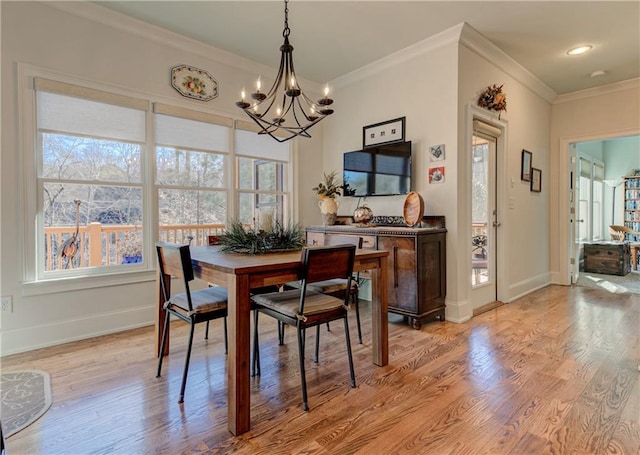 dining area featuring baseboards, ornamental molding, a notable chandelier, and light wood-style floors