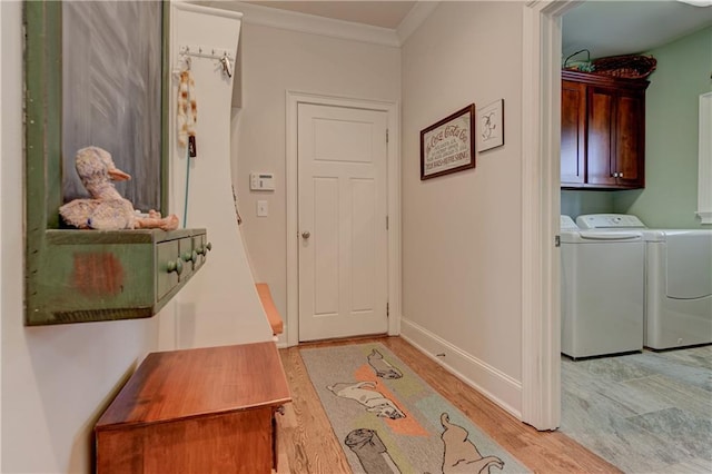 interior space featuring ornamental molding, separate washer and dryer, light wood-type flooring, and cabinet space