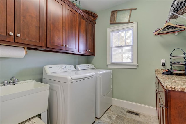 laundry room featuring a sink, visible vents, baseboards, independent washer and dryer, and cabinet space