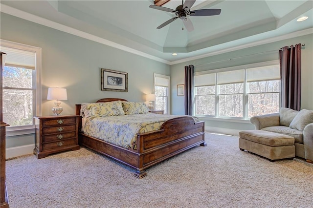 bedroom with a ceiling fan, a tray ceiling, baseboards, and carpet