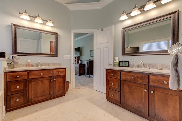 full bathroom with crown molding, two vanities, and a sink