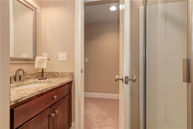 bathroom featuring vanity, baseboards, and an enclosed shower